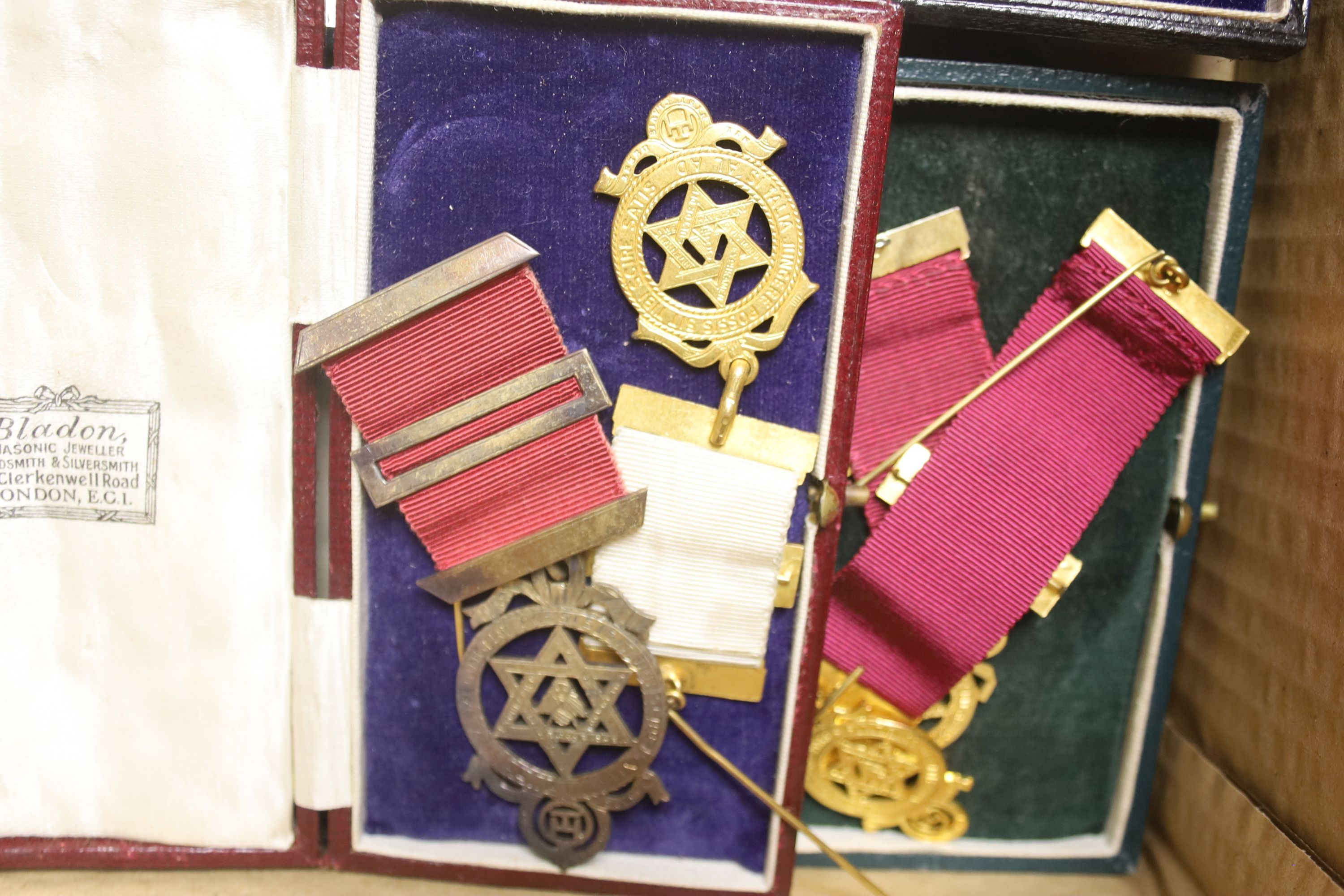 A group of Masonic sashes with metal medals and a collection of gilt metal cased medals